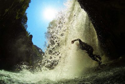 Jump through the waterfall into clear lake of Cetina